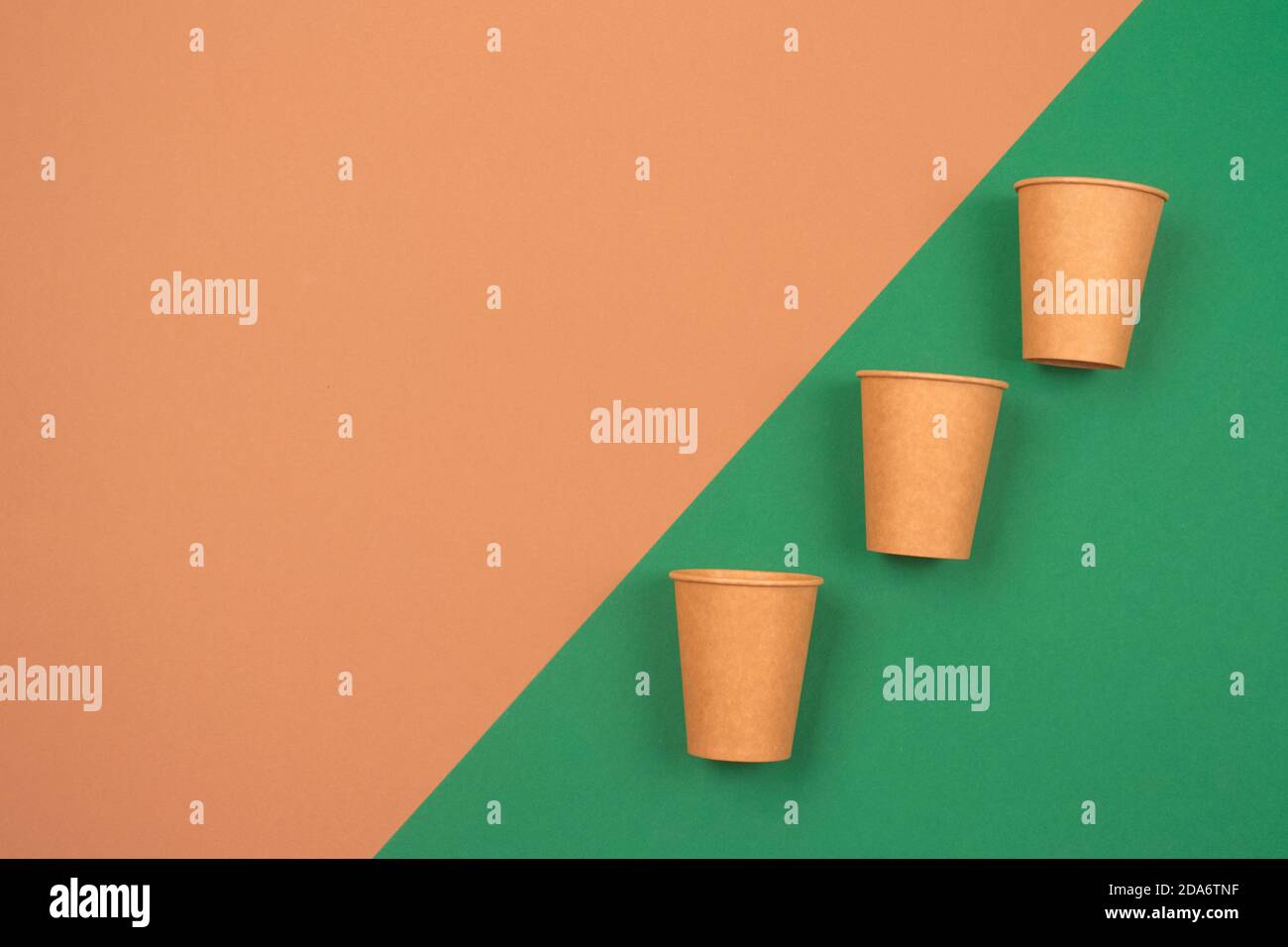 Set of ecofriendly takeaway beverages cups kraft paper coffee cups on green and brown