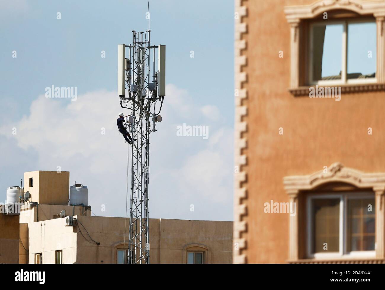 An Egyptian technician fixes a mobile communication antenna at the top