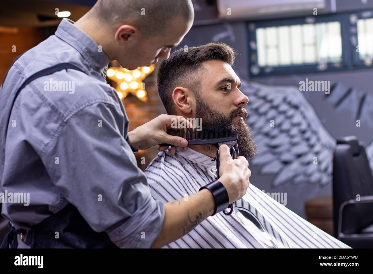 Beard styling and cutting with trimmer. Young bearded hipster man getting haircut / beard cut by professional hairdresser barbershop. Movember Stock Photo - Alamy