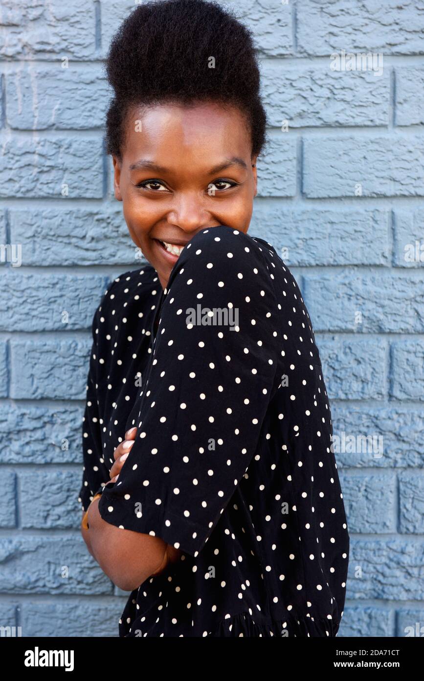 Close up portrait of cute african woman standing with her arms crossed ...