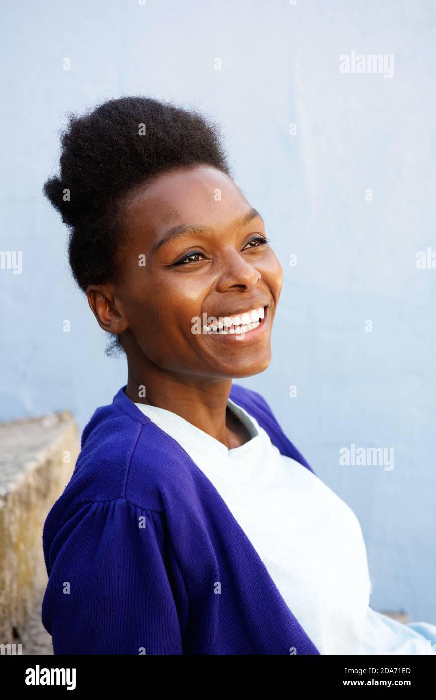 Close up portrait of smiling young african woman sitting outdoors Stock ...