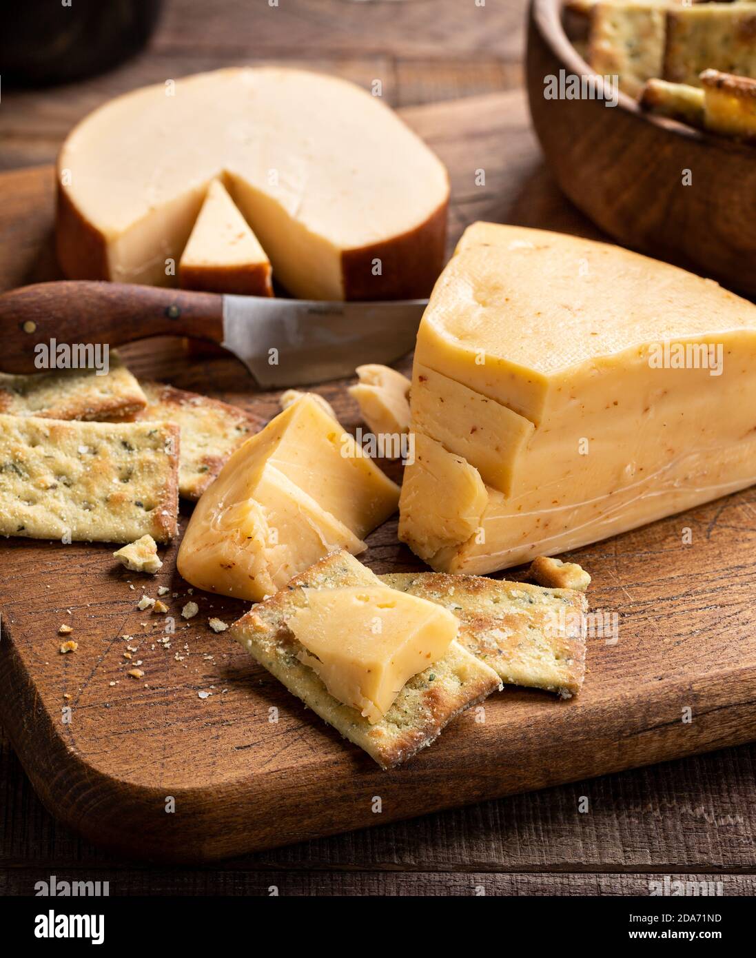 Gouda cheese and crackers on a rustic cutting board Stock Photo