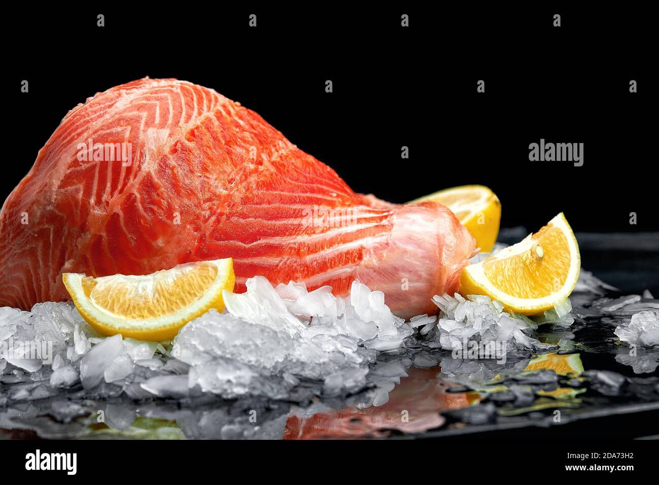 Fresh raw salmon fish steak on ice over dark stone background. Creative ...