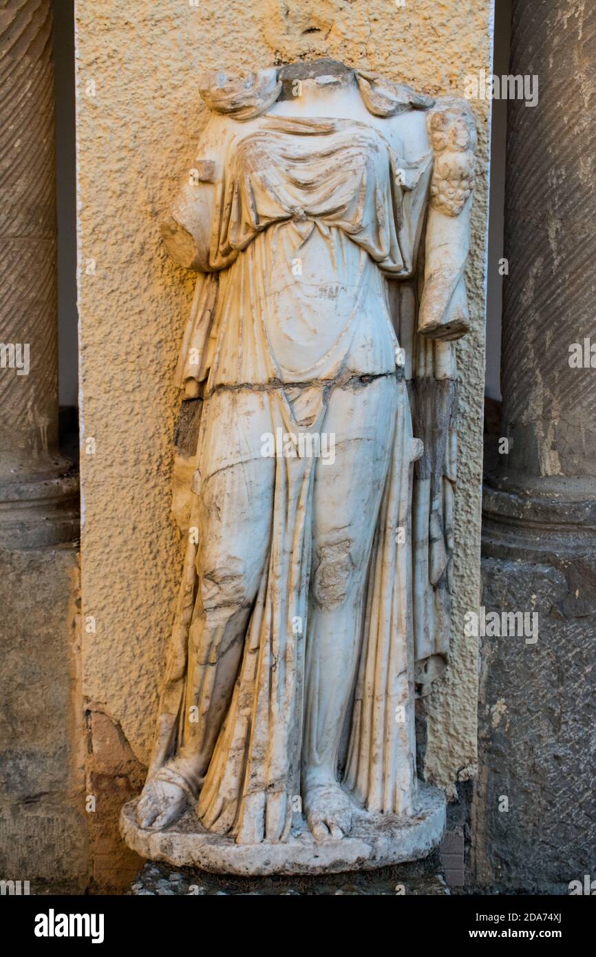 Vertical shot of a headless statue in the famous Roman ruins in Timgad
