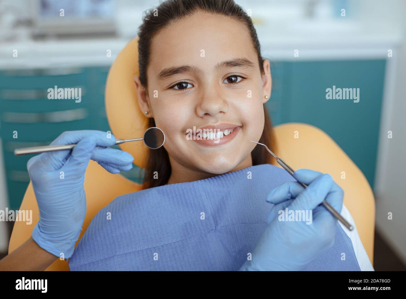Little girl being treatment by dentist at dental clinic, hands of