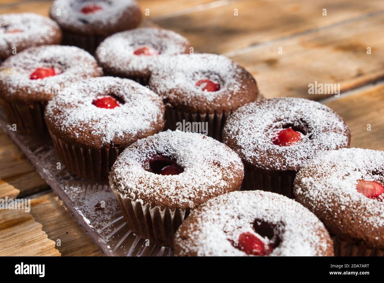 Rows of homemade cupcakes with strawberry centres. High angle view. Stock Photo