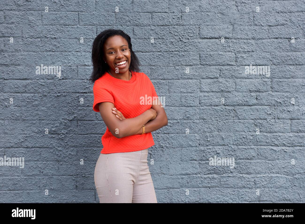 Portrait of young african woman standing with crossed arms Stock Photo ...