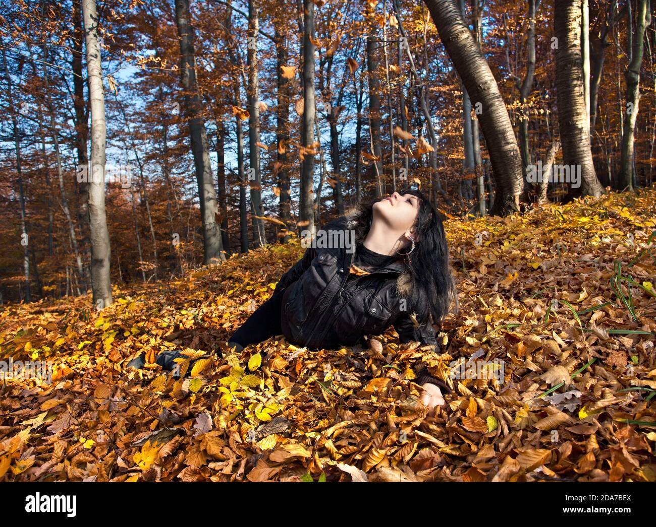 Young woman lying in fallen autumn leaves Stock Photo - Alamy