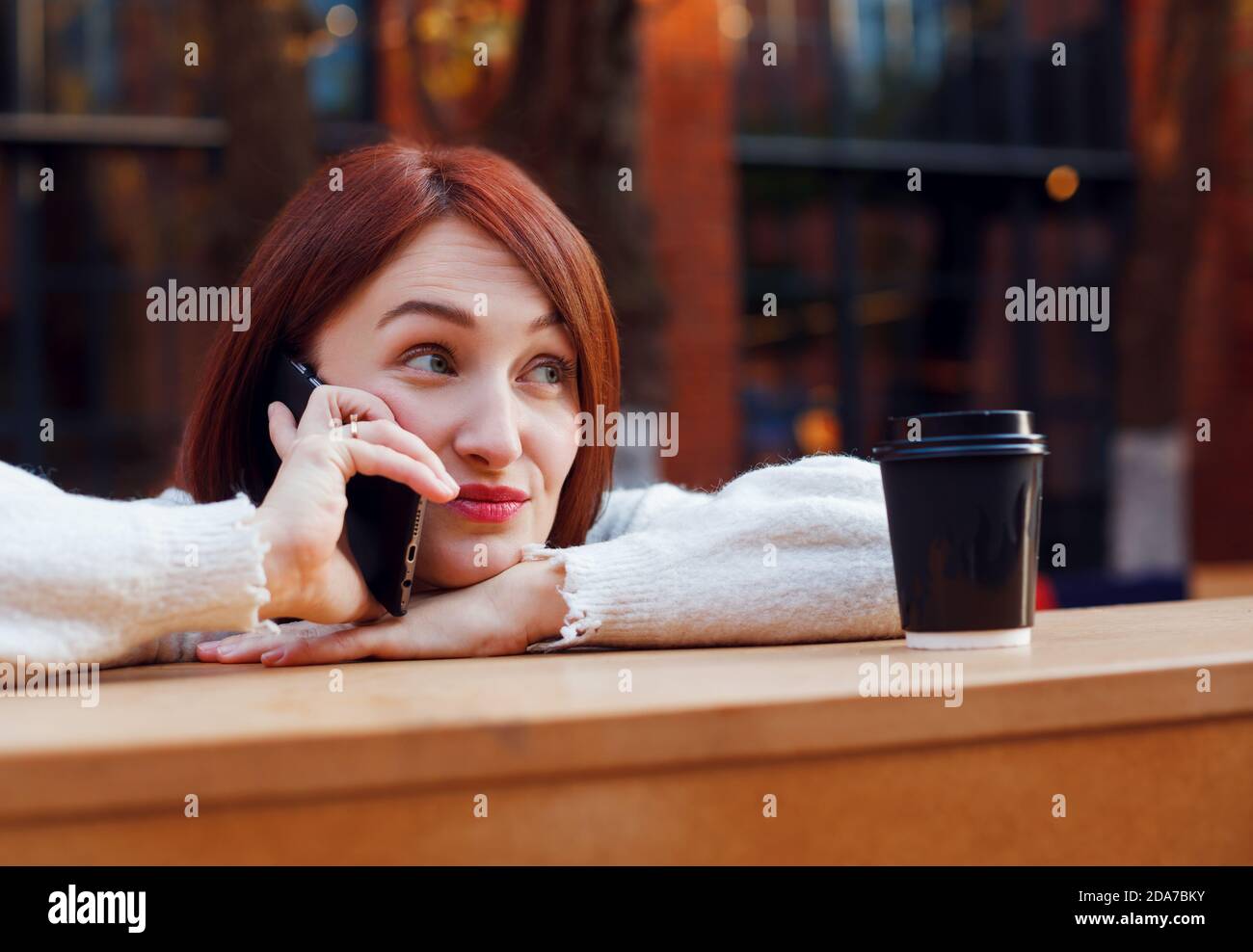 Woman hanging on a phone with raised brows expression on her face. Chatting with friends concept. Stock Photo