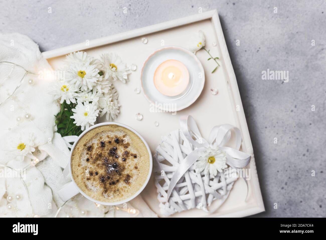 Cozy morning moments at home with cup of coffee, candles and flowers. on a wooden tray. Flat lay for bloggers. Stock Photo