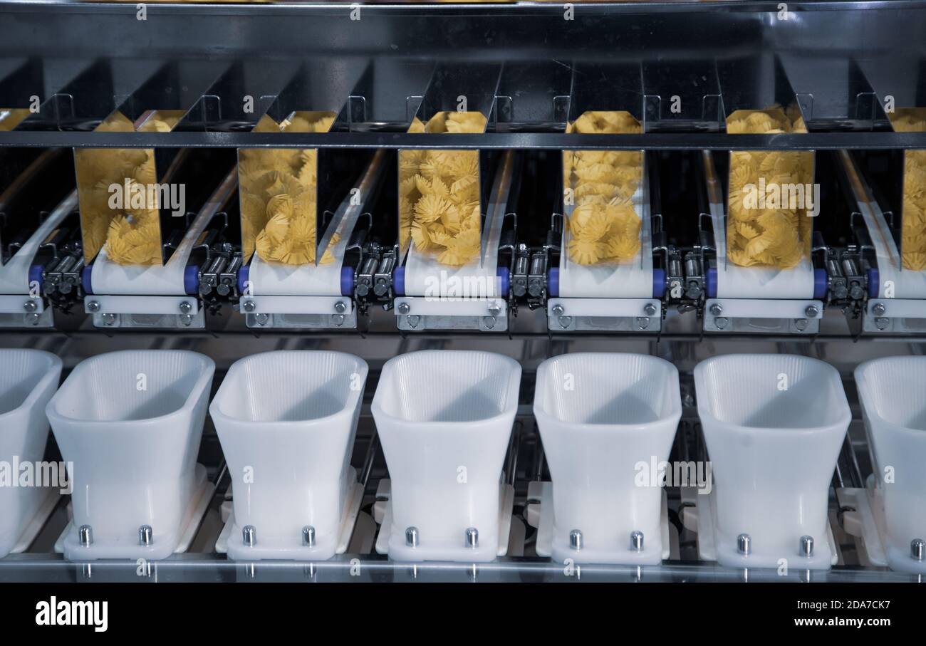 Dry pasta on automatic combination weighers. Multihead weighers machine in food industry. Stock Photo
