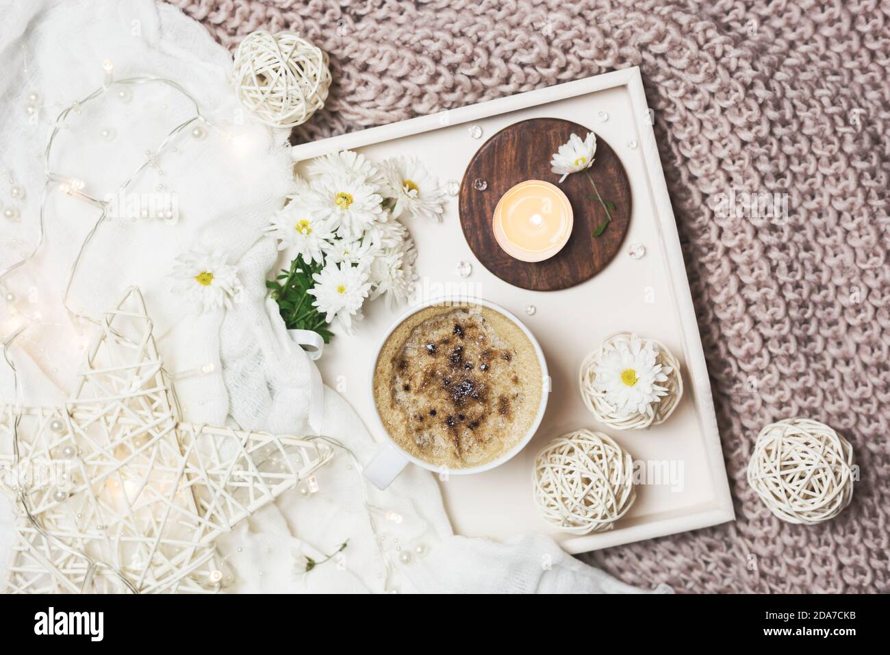 Cozy morning moments at home with cup of coffee, candles and flowers. on a wooden tray. Flat lay for bloggers. Stock Photo