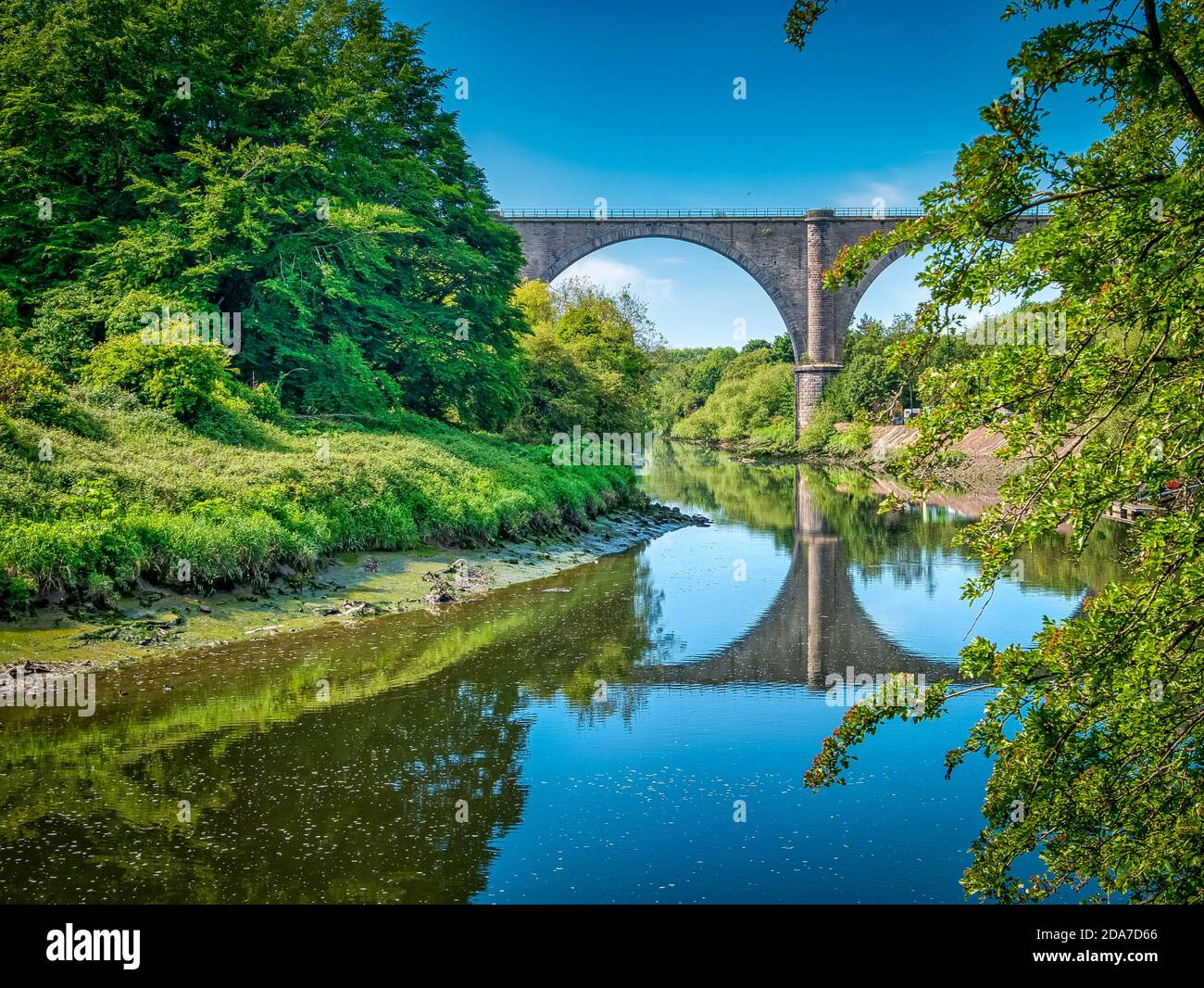A bright summers day in Washington, UK with the Victoria Viaduct casting its reflection across the River Wear Stock Photo