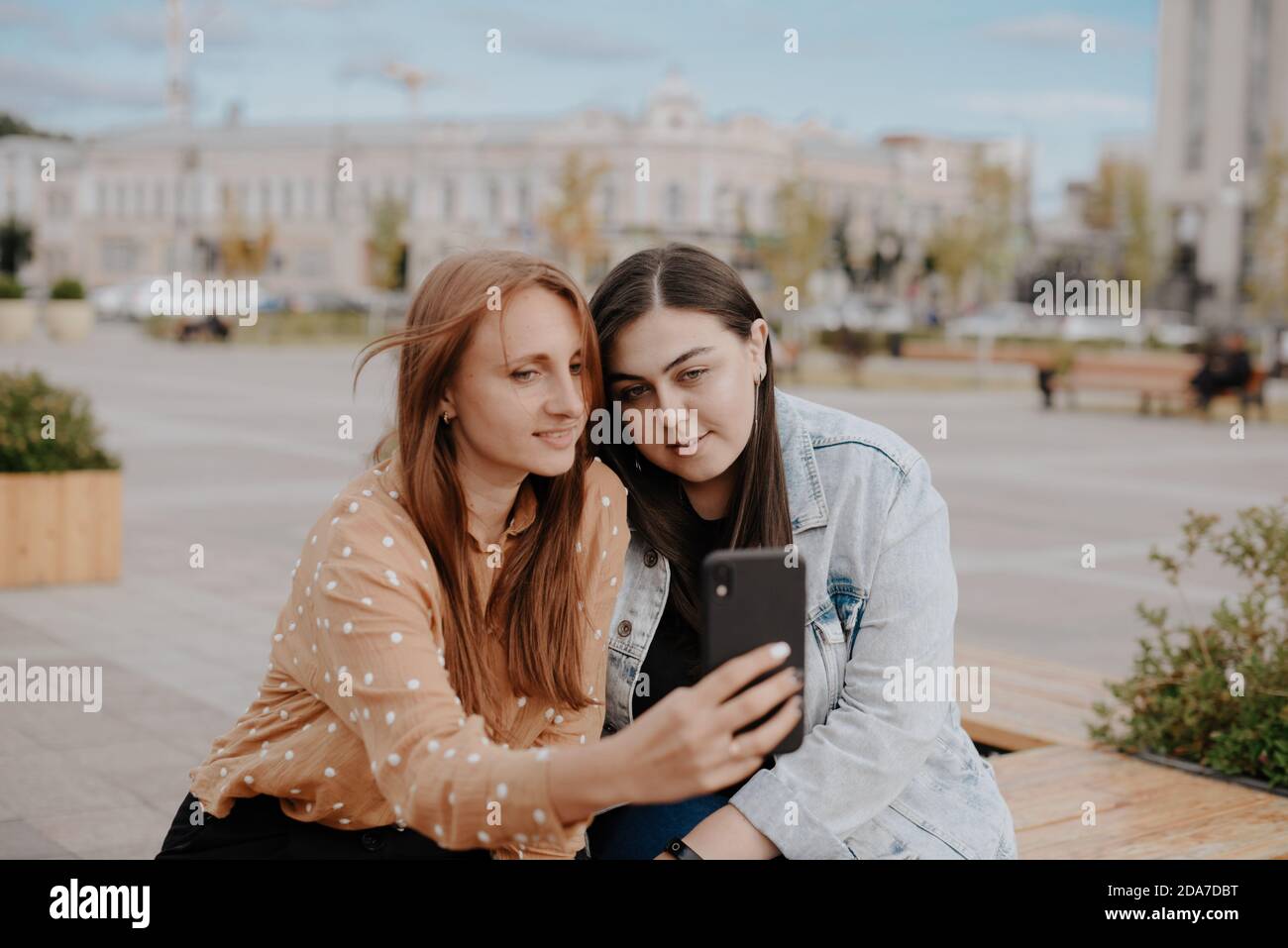 Two young women sit hi-res stock photography and images - Alamy