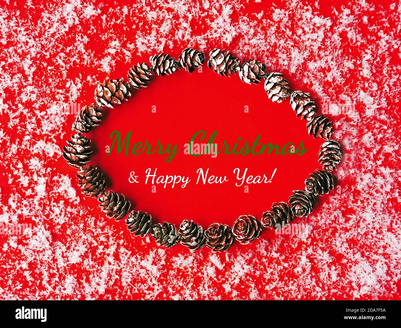 festive red and white christmas greeting card with snow, pine cones and an oval copy space Stock Photo