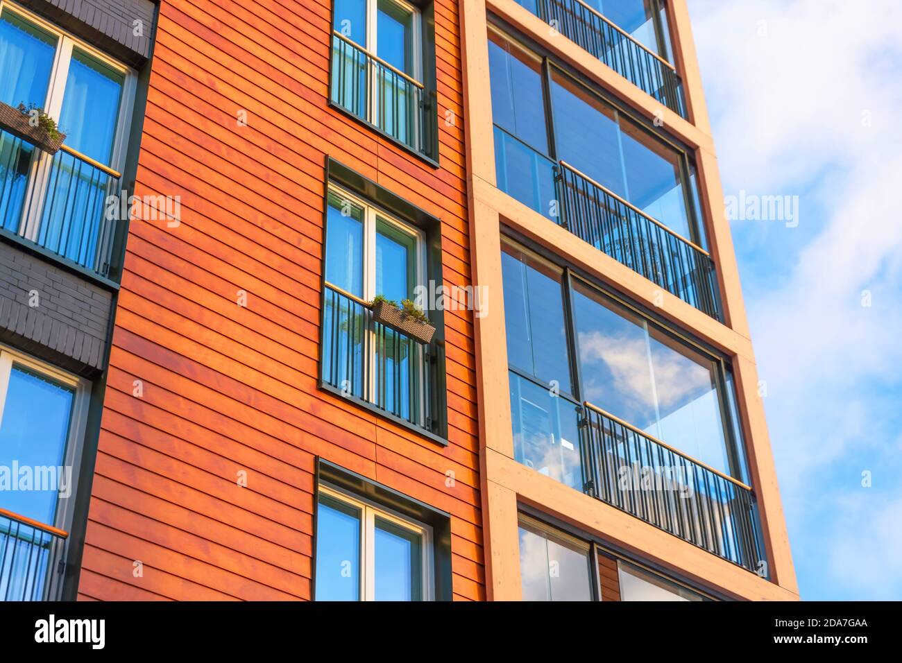View of a modern residential brown building with balconies and windows