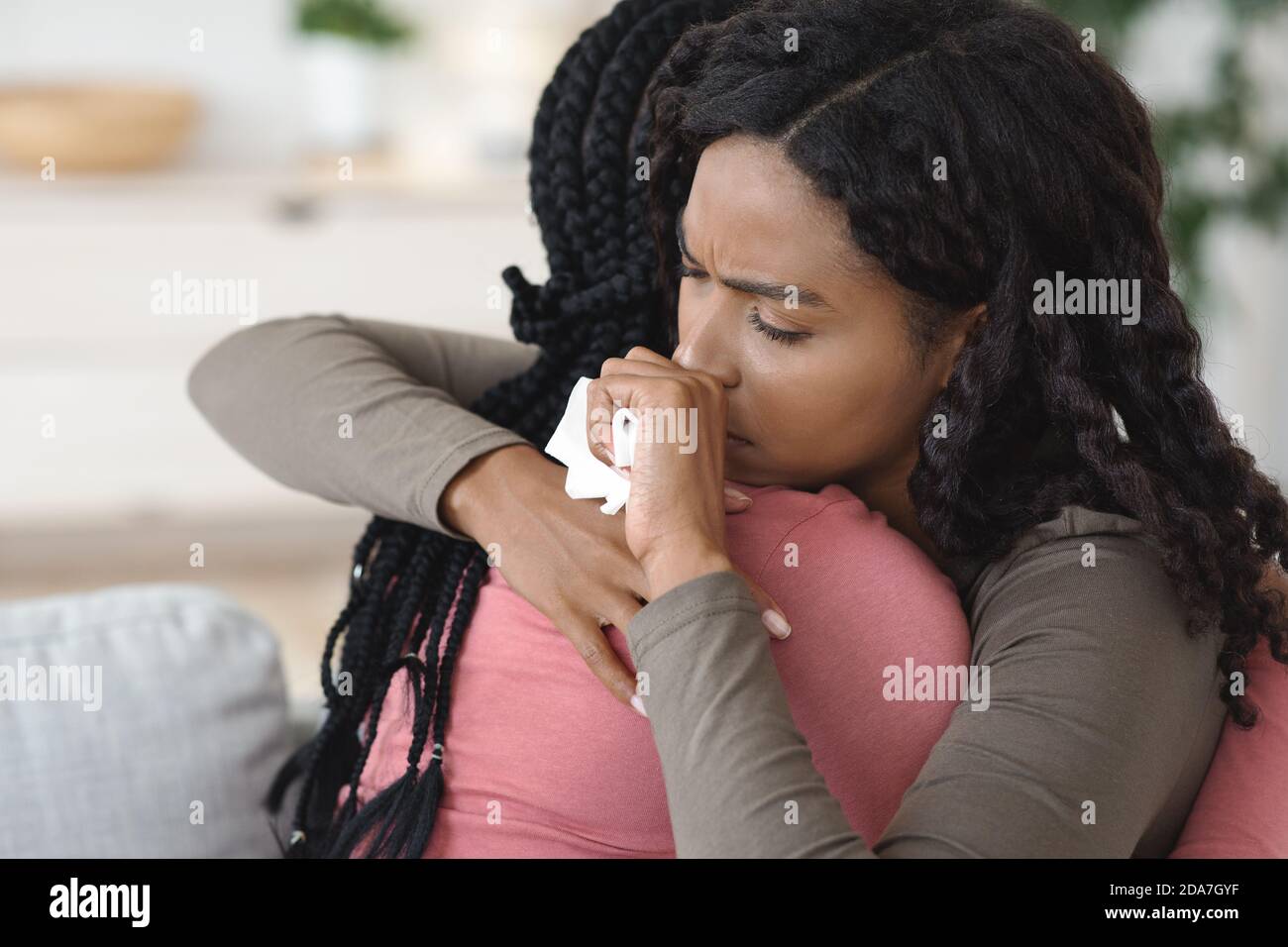 Crying black woman hugging her girlfriend or sister Stock Photo