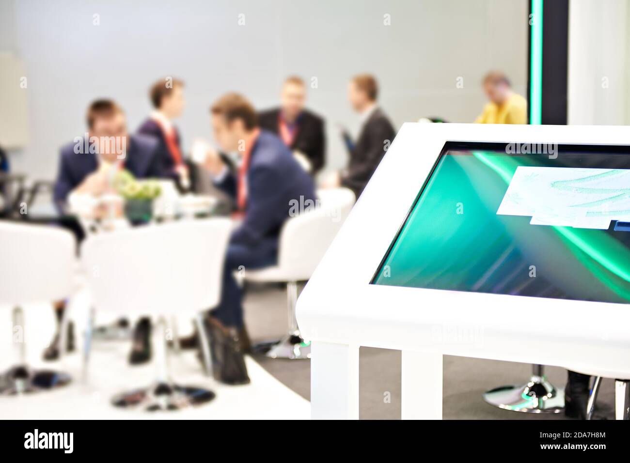 Information touchscreen monitor and businessmen at a modern business exhibition Stock Photo