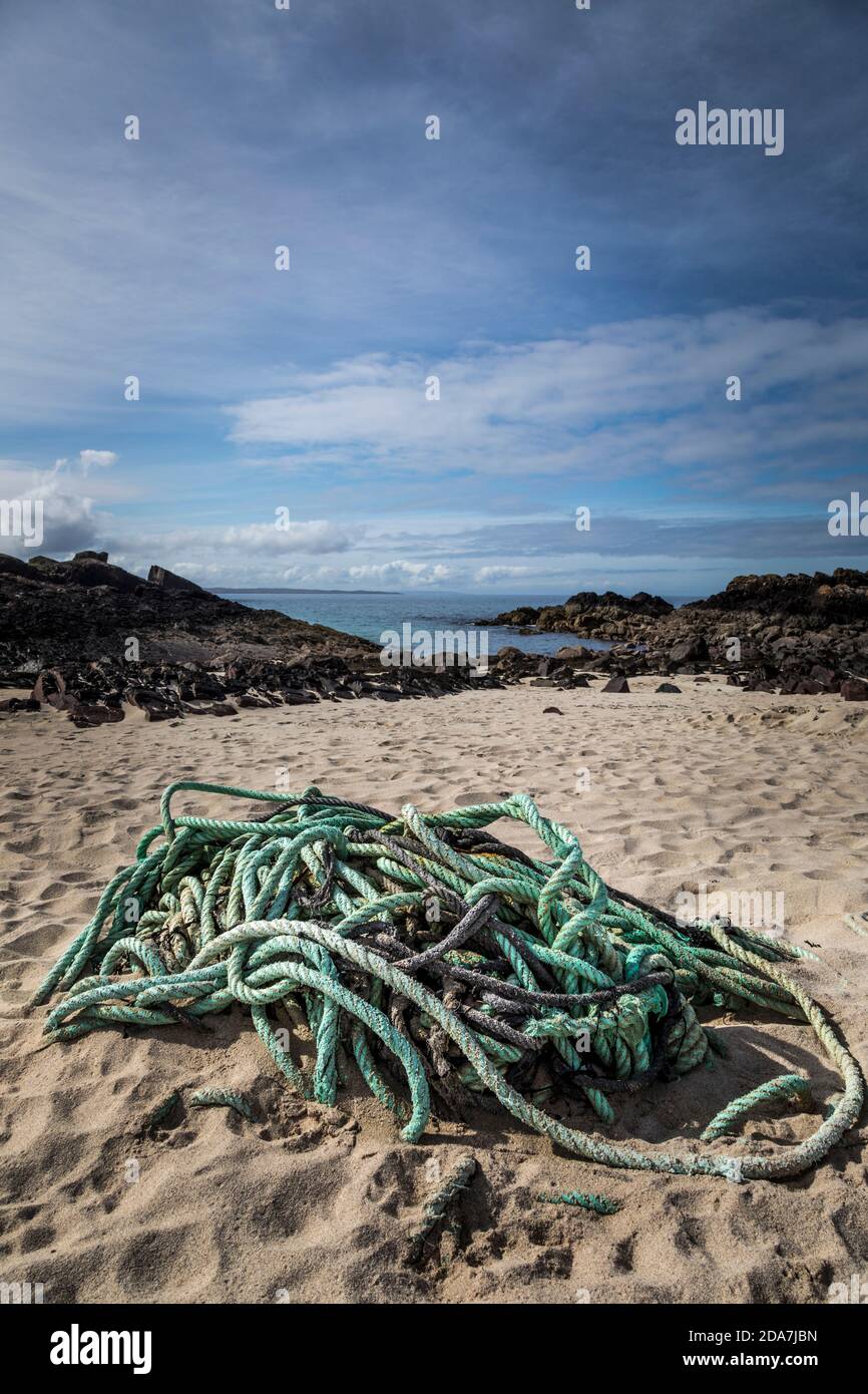 Green nylon rope abandoned on a sandy beach at Clachtoll, Scotland. Stock Photo