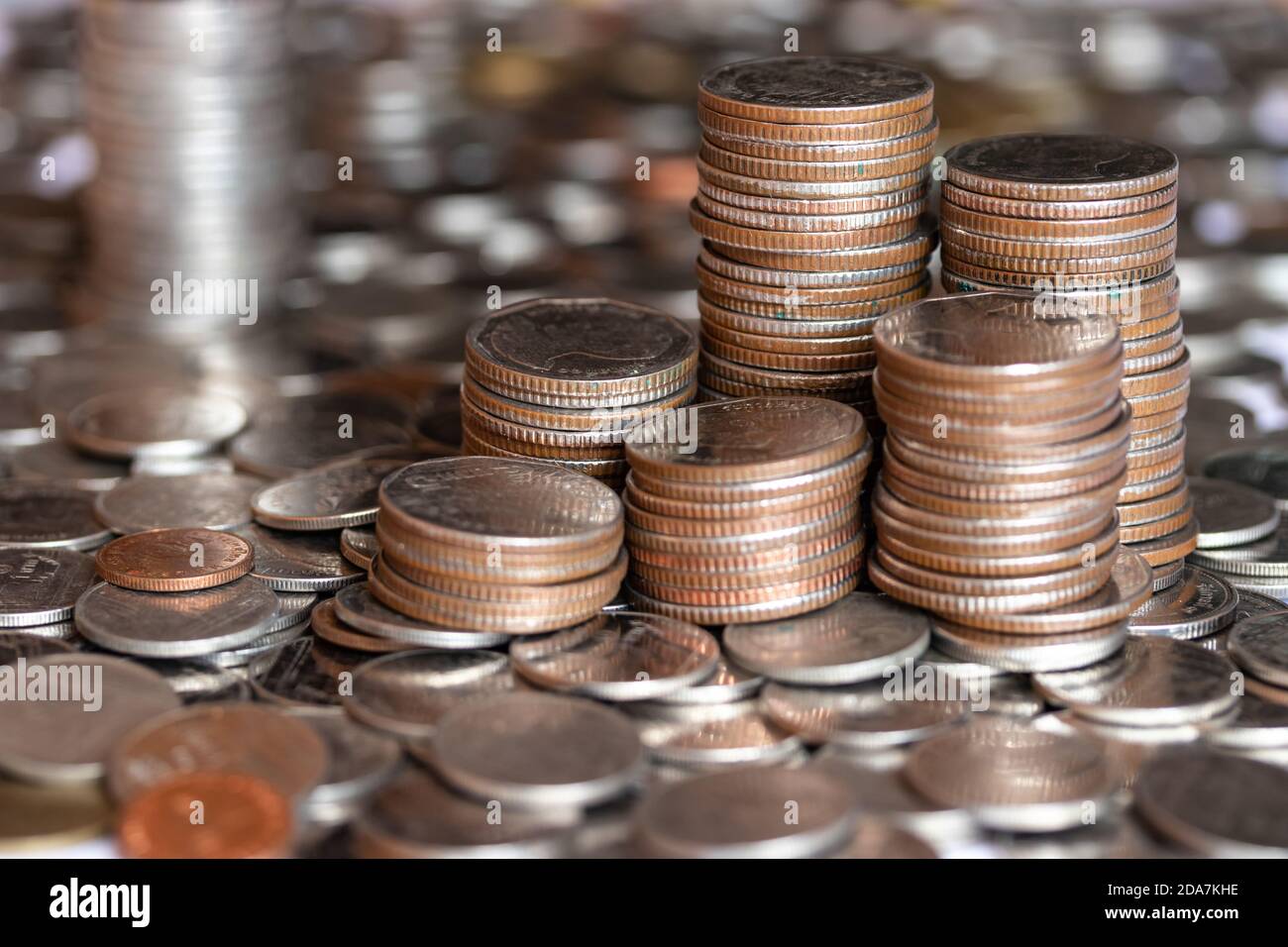 Focus silver coins, golden coins stacked on each other in different positions. A pile of Coins on baht coin background. Stock Photo