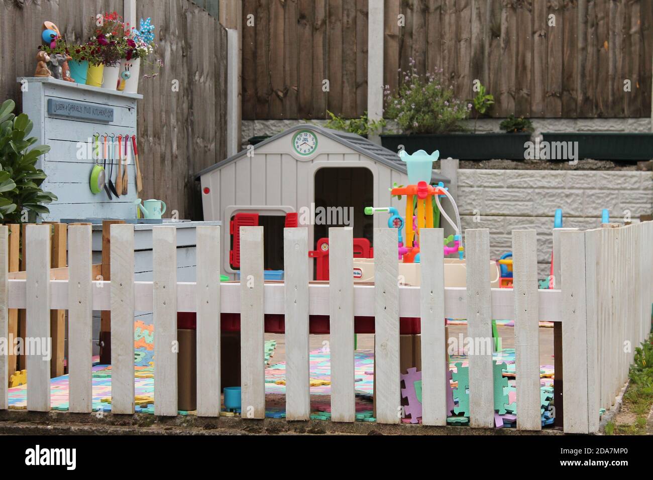 Kids play area fenced off in a garden to allow children to play safely during UK lockdown Stock Photo
