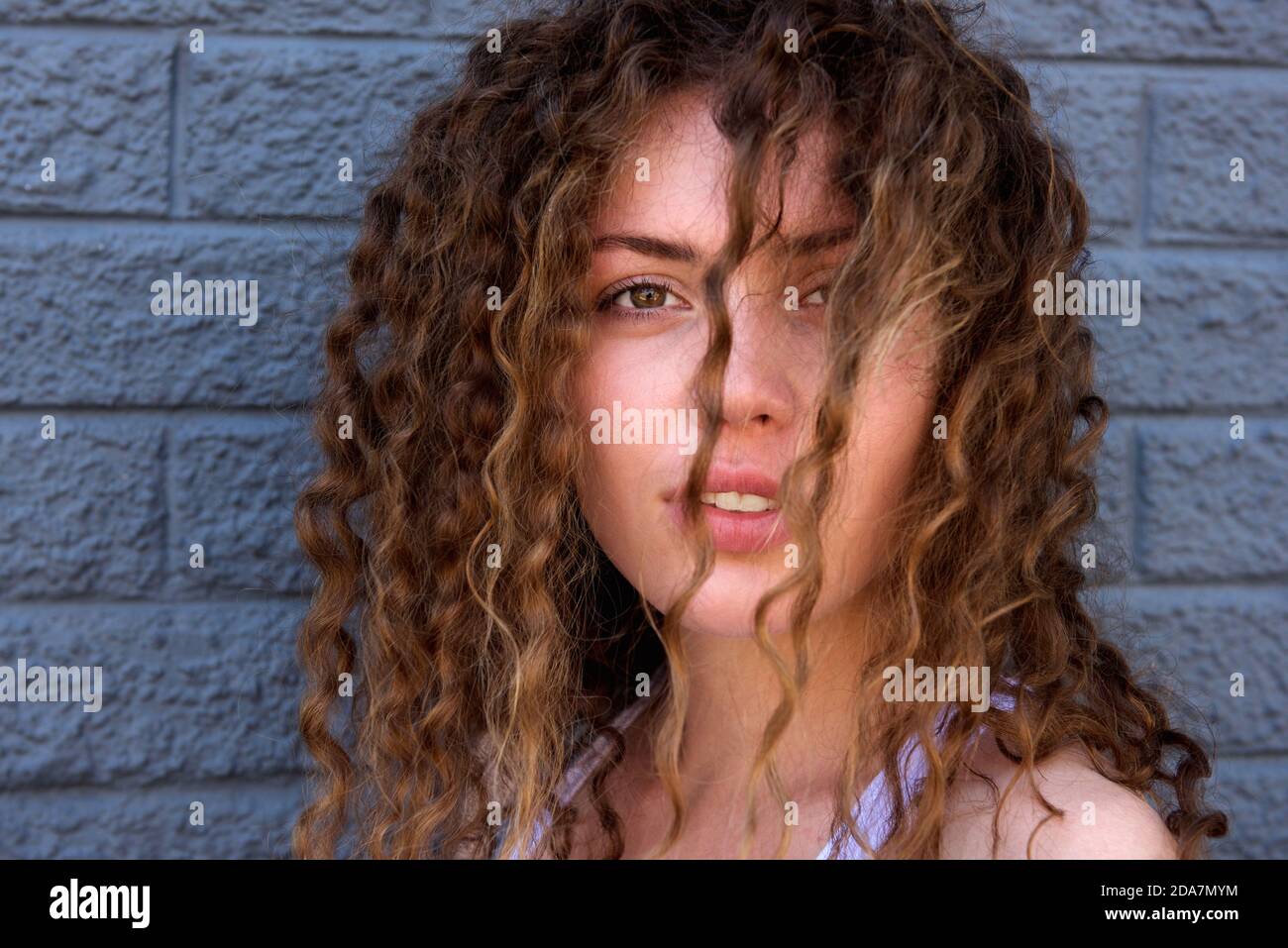 Close up portrait of beautiful young woman with hair in face staring Stock Photo