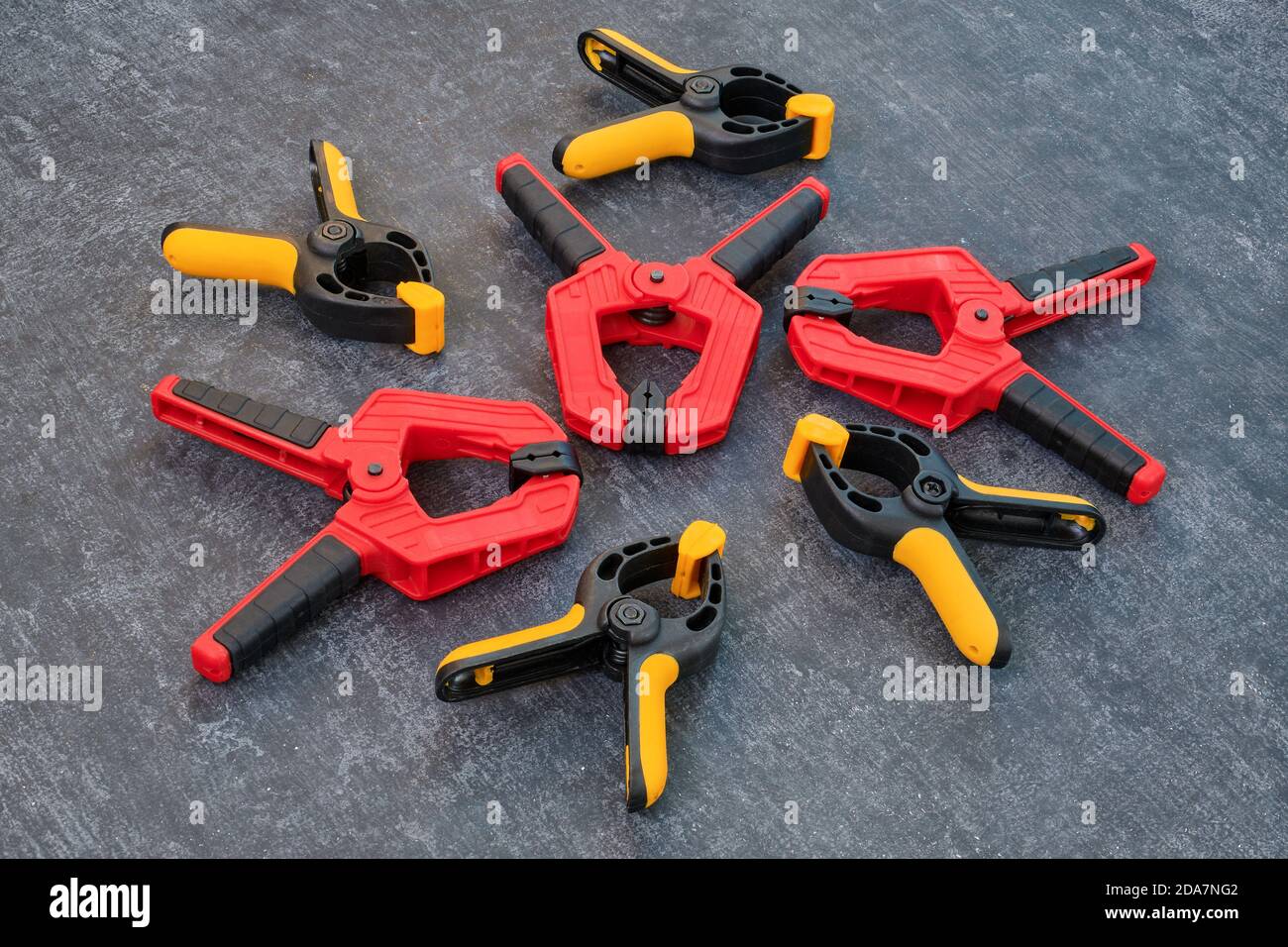 Red and yellow spring clamps. Set of small and medium. Clamping tools for carpentry work. Stock Photo