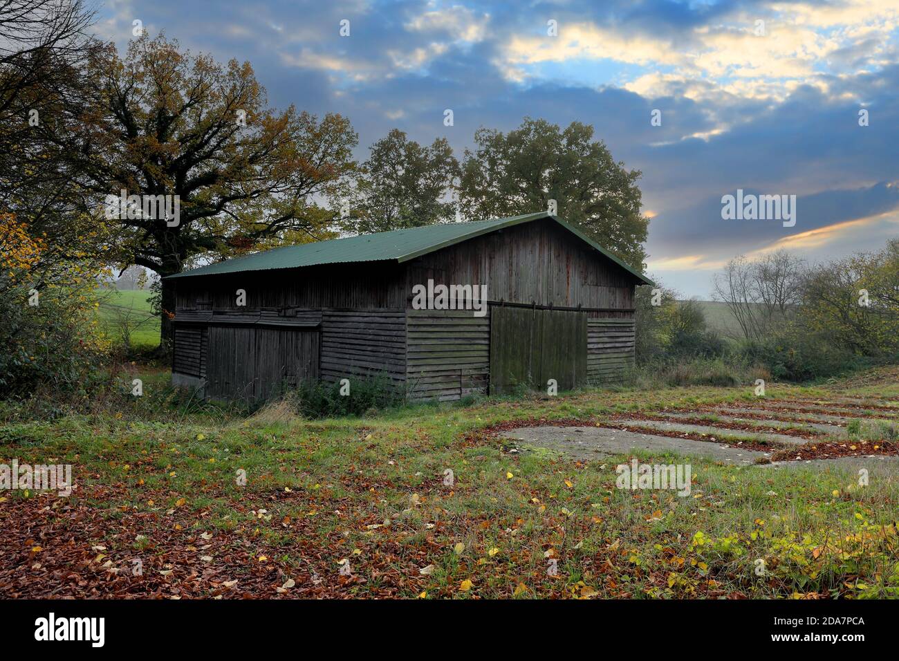 An outbuilding made of brown wood and a green roof. It's near Malente. Stock Photo