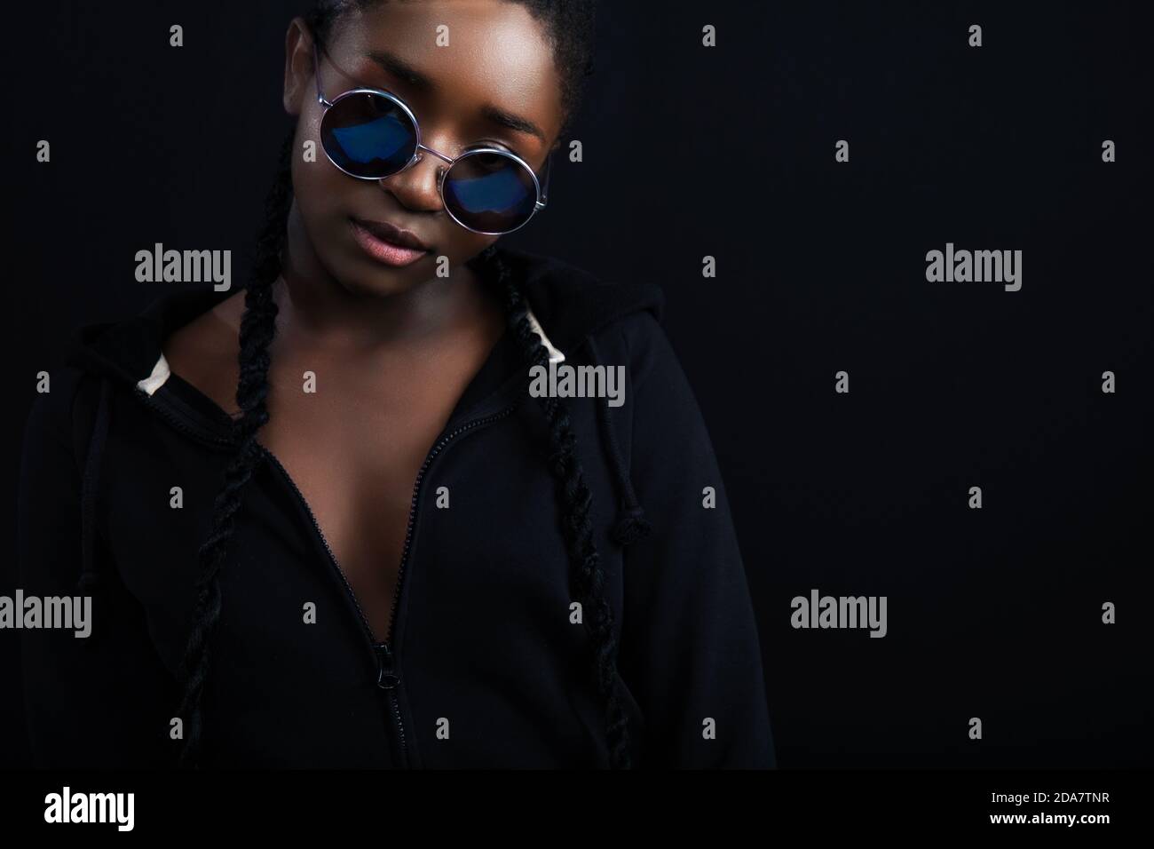 Confident african woman with dark skin wearing round sunglasses Stock