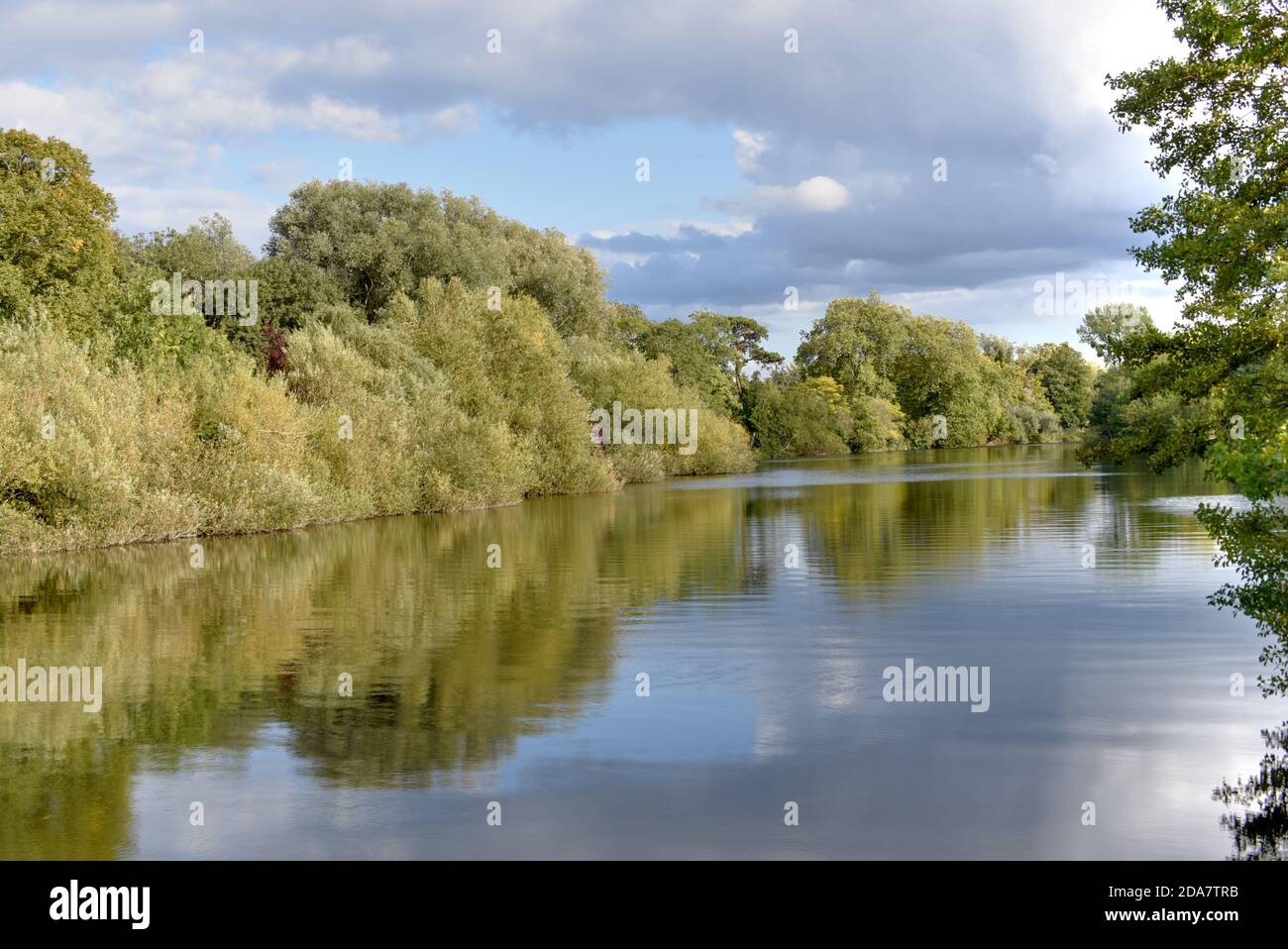 Trees are reflected in the River Thames in this photo taken on a clear autumn day near Egham in Surrey Stock Photo
