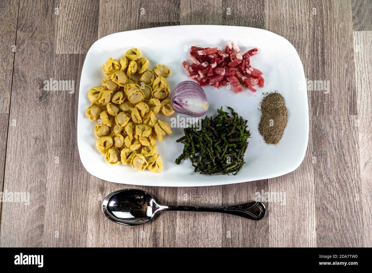 ingredients for cappelletti pancetta and asparagus creamed in a pan with parmesan Stock Photo