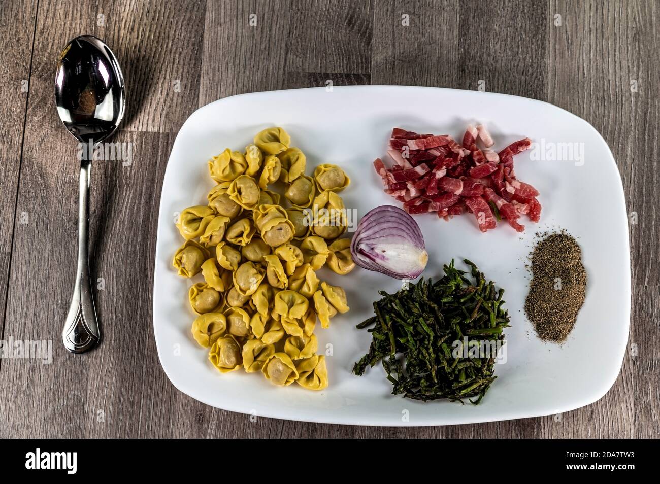 ingredients for cappelletti pancetta and asparagus creamed in a pan with parmesan Stock Photo