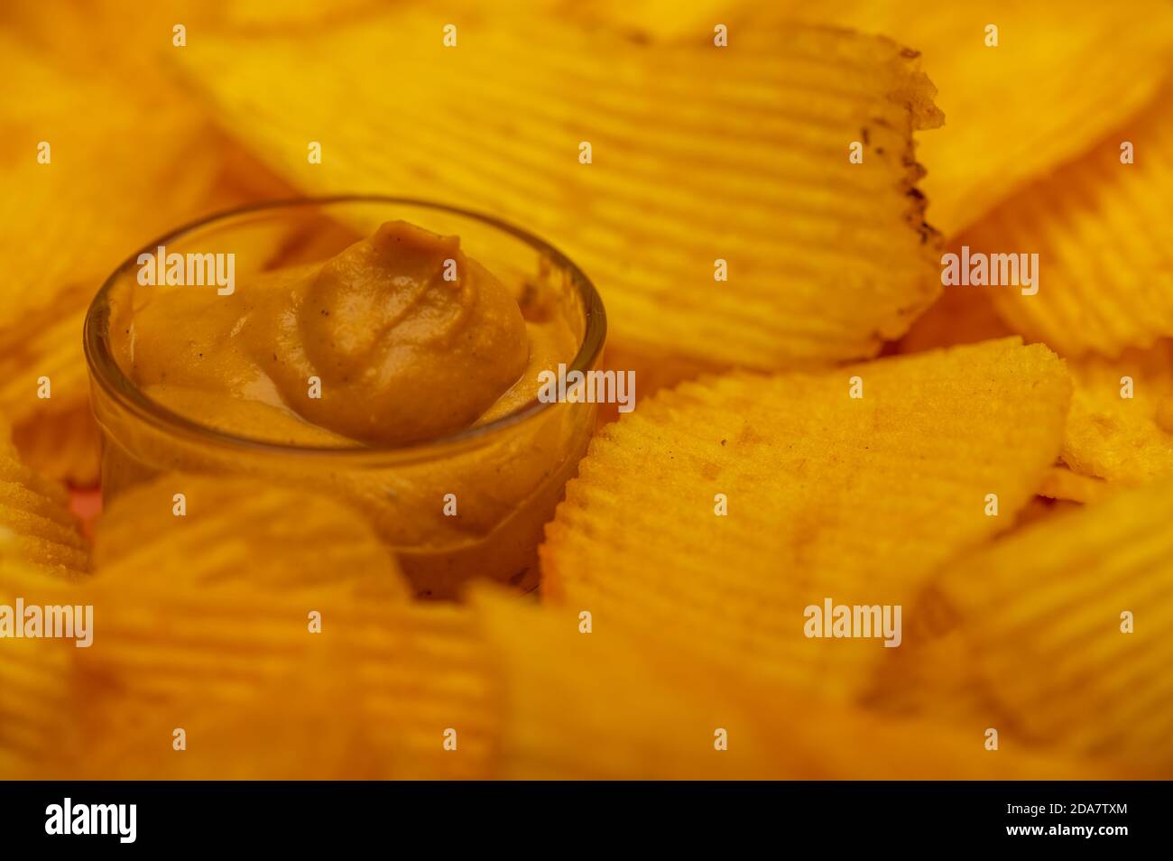 Crispy, delicious potato chips with mustard sauce. Close up Stock Photo