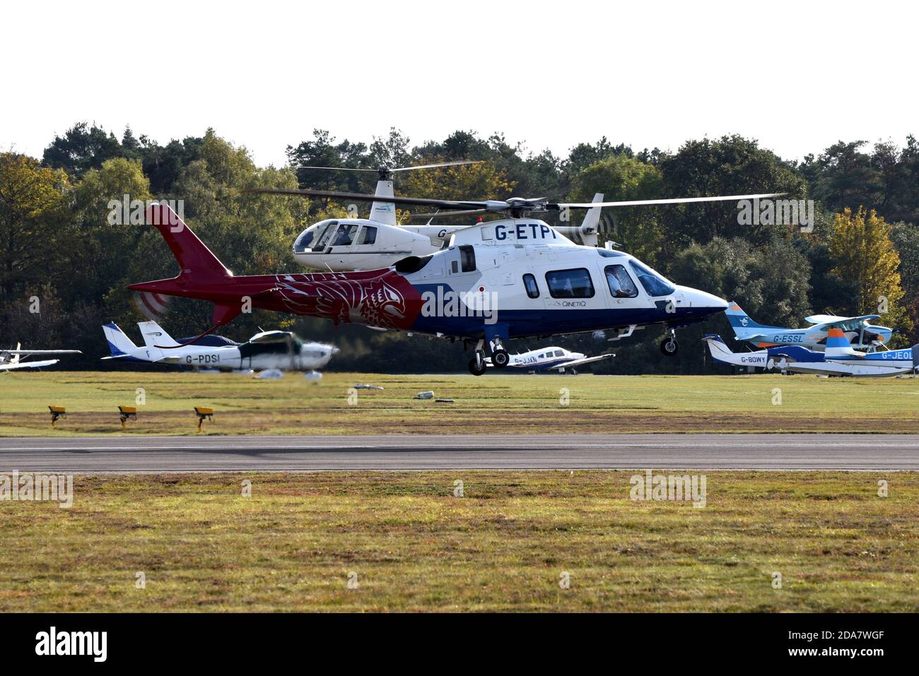 Two helicopters hover close to the ground in this photograph taken in Hampshire Stock Photo