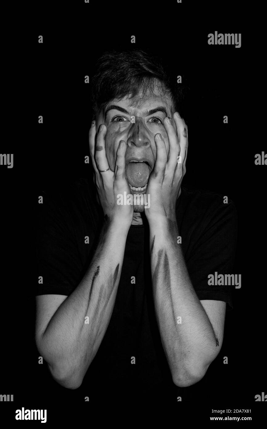 Dirty man with hands on his face Stock Photo - Alamy