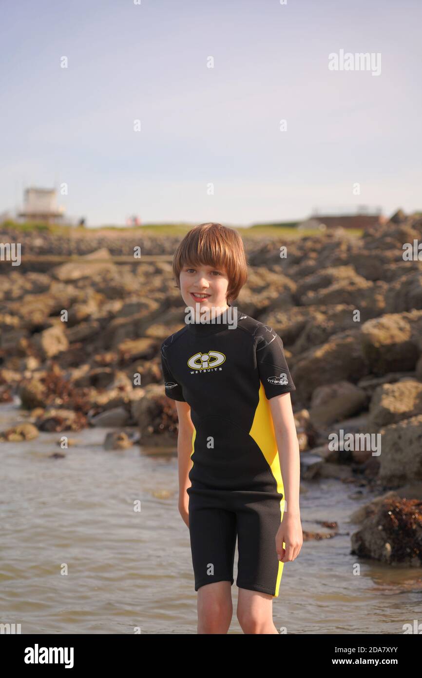 Young boy in a wetsuit by sea Stock Photo Alamy