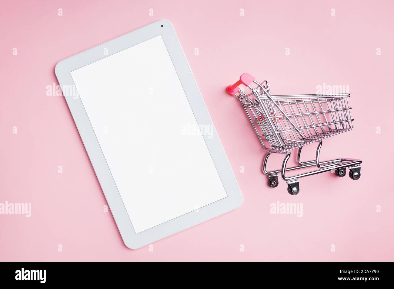 Mini shopping cart and tablet with empty white screen Stock Photo