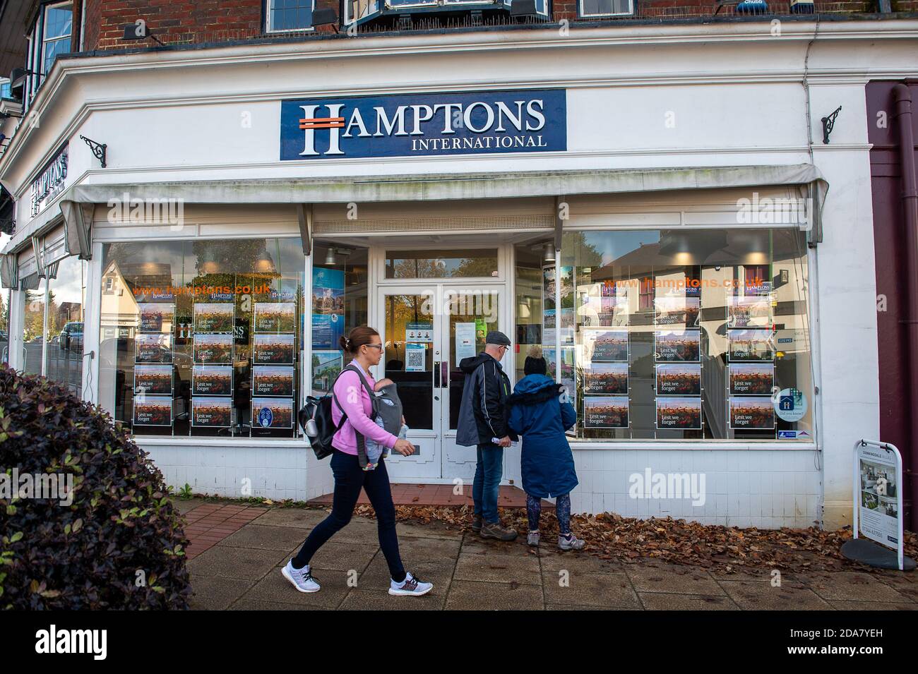 Sunningdale, Berkshire, UK. 10th November, 2020. A couple look at details of properties for sale in the Hamptons International Estate Agents during the Covid-19 Coronavirus lockdown 2. Credit: Maureen McLean/Alamy Live News Stock Photo