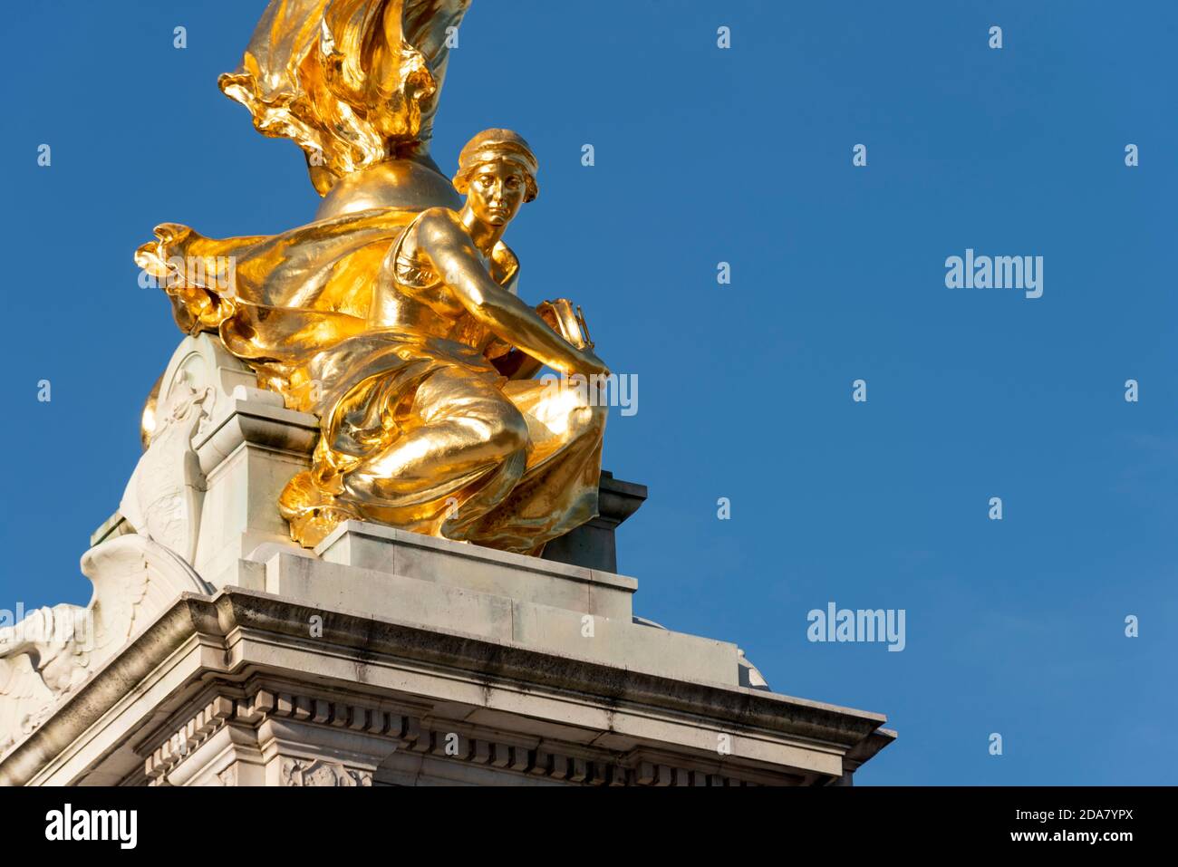 A detail of the Victoria Memorial outside Buckingham Palace in The Mall, London, UK. This is Constancy, below Winged Victory, in gilt gold, blue sky Stock Photo
