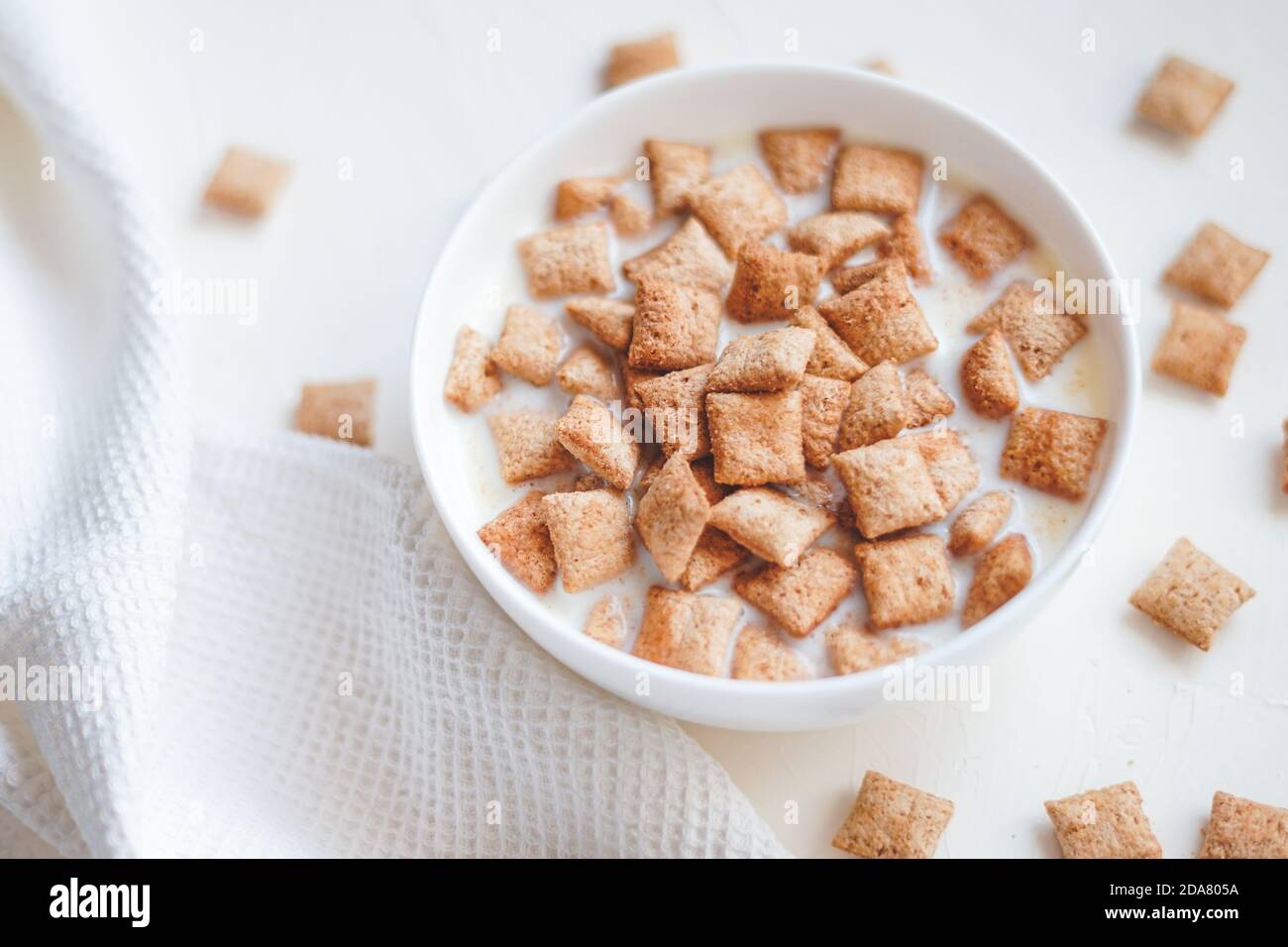 Dry breakfast cereal pads with milk on a white concrete background  Stock Photo