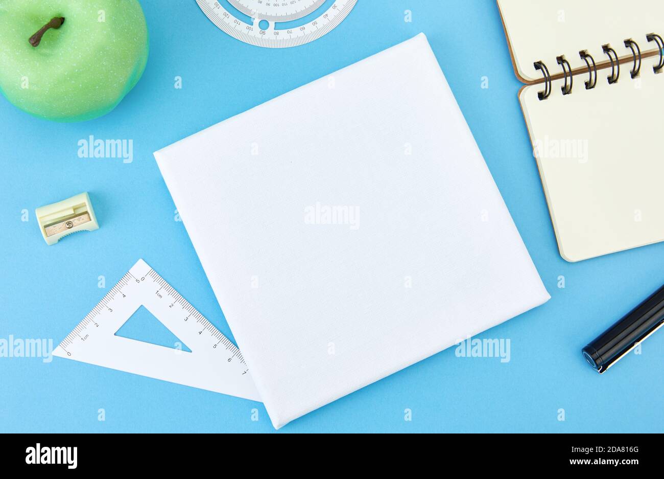 High angle shot of a paper, a notebook, some stationary on a blue surface Stock Photo