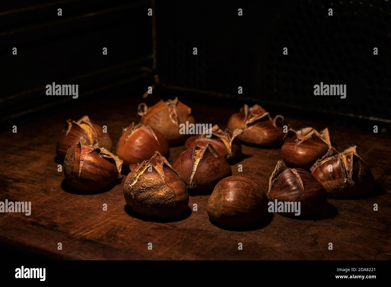 Sweet chestnuts, Castanea sativa, in the oven on a stoneware plate ...