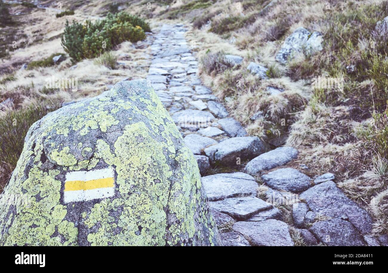 Mountain hiking trail marker on a rock, selective focus, color toned picture, Karkonosze National Park, Poland. Stock Photo