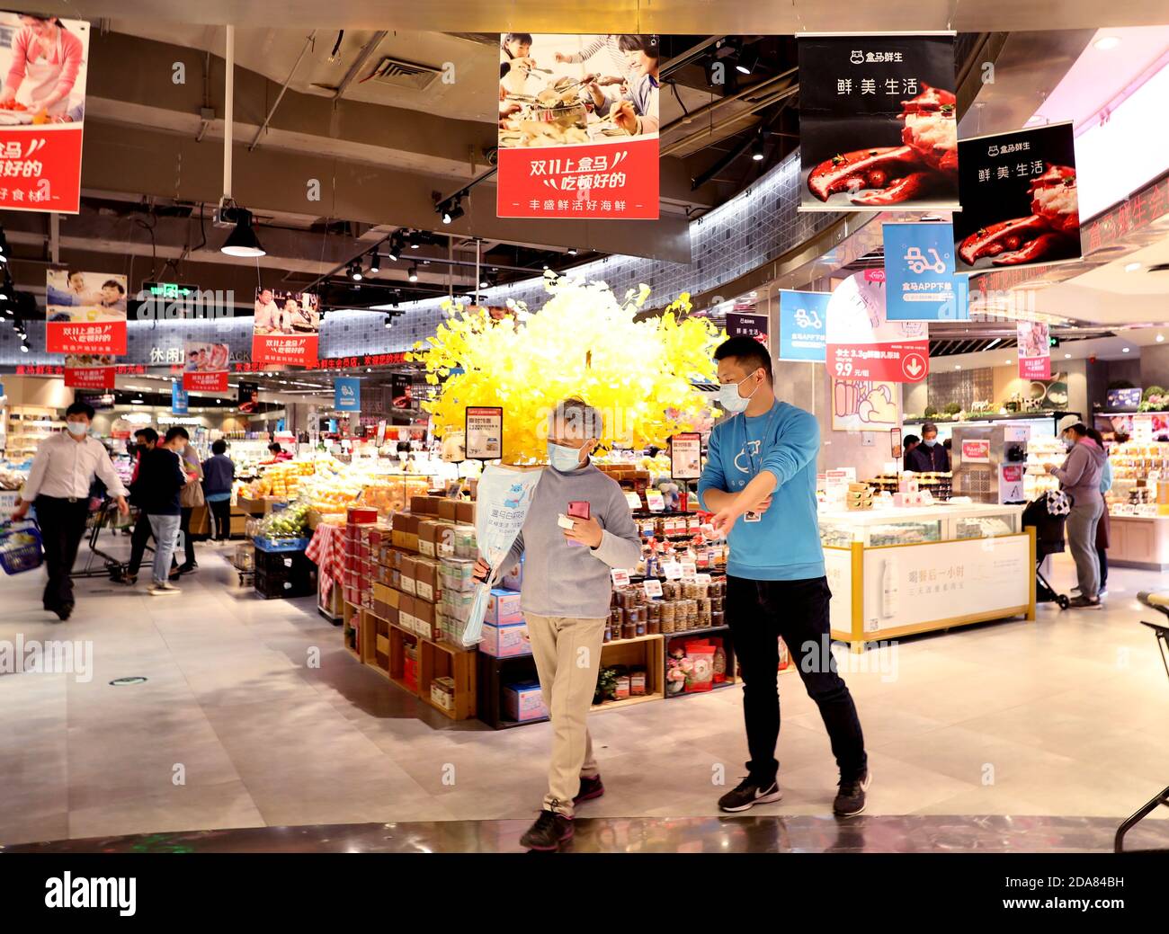 201110) -- SHANGHAI, Nov. 10, 2020 (Xinhua) -- Wang Longchi (R) talks with  a customer at a Hema Fresh store in Pudong of east China's Shanghai, Nov.  10, 2020. Wang, 43, is