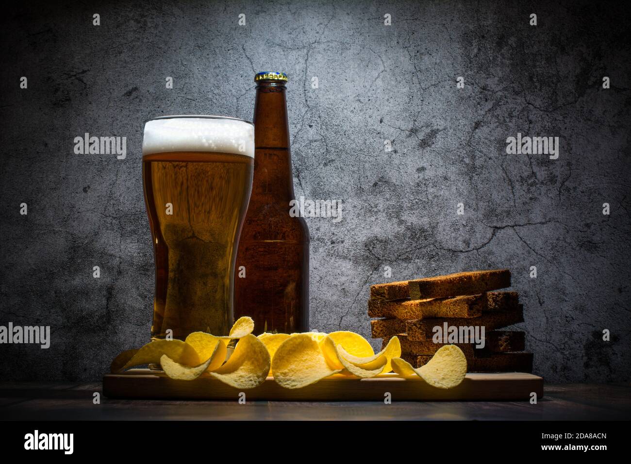 Lager beer and snacks on stone table. Nachos, chips side view Stock Photo