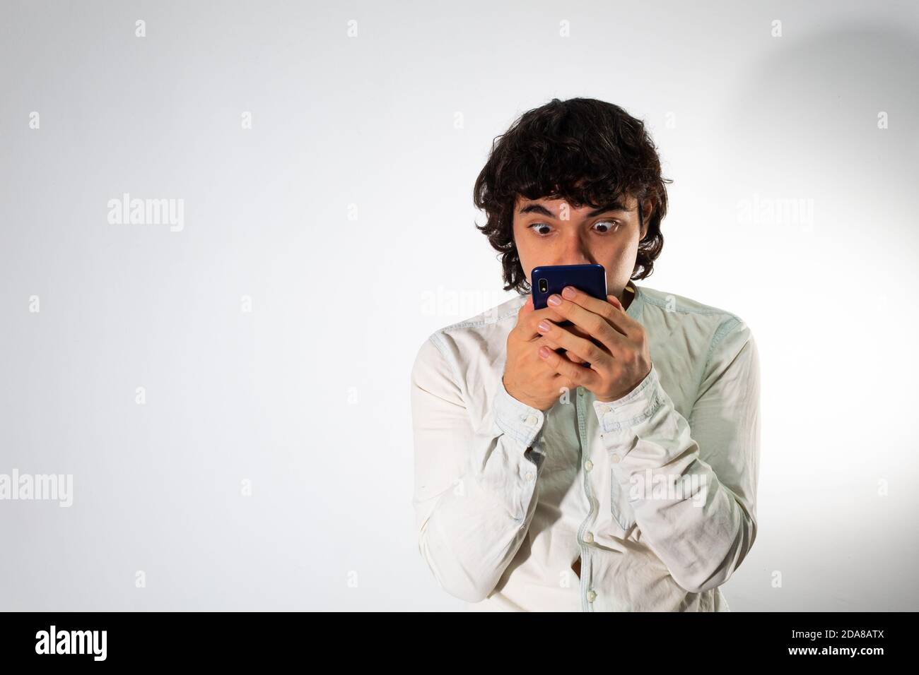 Young Hispanic man wearing casual clothes on a white background with a shocked expression Stock Photo