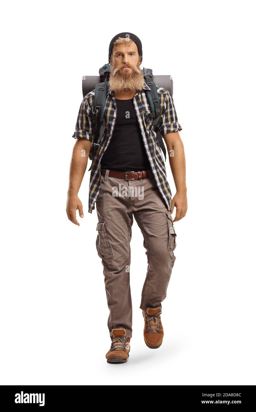 Full length portrait of a young bearded hiker with a backpack walking towards camera isolated on white background Stock Photo