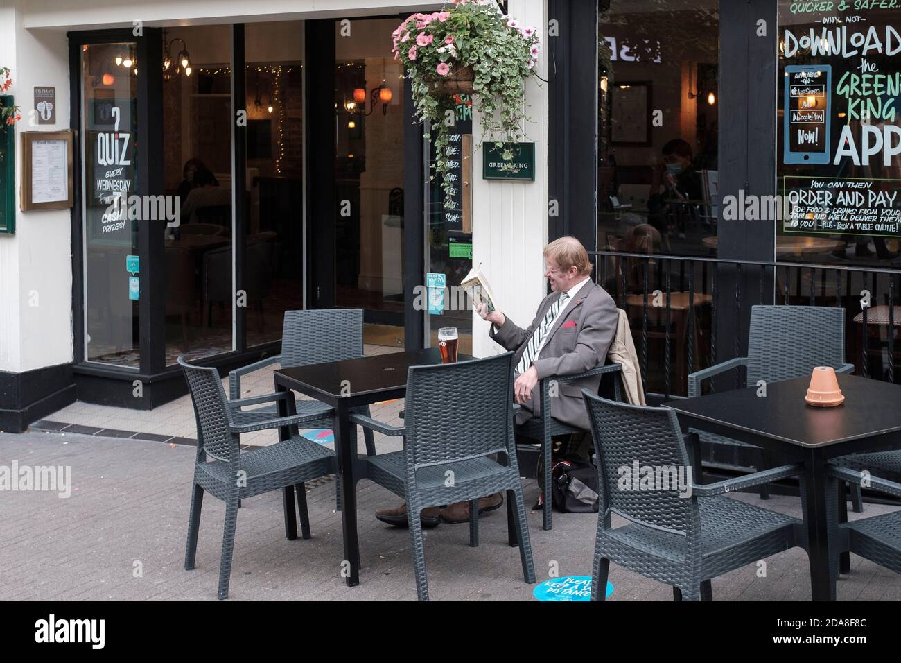 Man reading a book  and enjoying a pint outside a pub,London,UK Stock Photo