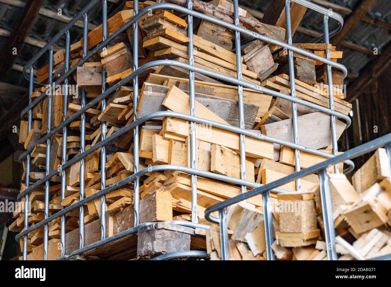 Pieces of firewood in a large basket or shelter made of metal, fire wood is  often used for heating up rooms and houses with a oven Stock Photo - Alamy