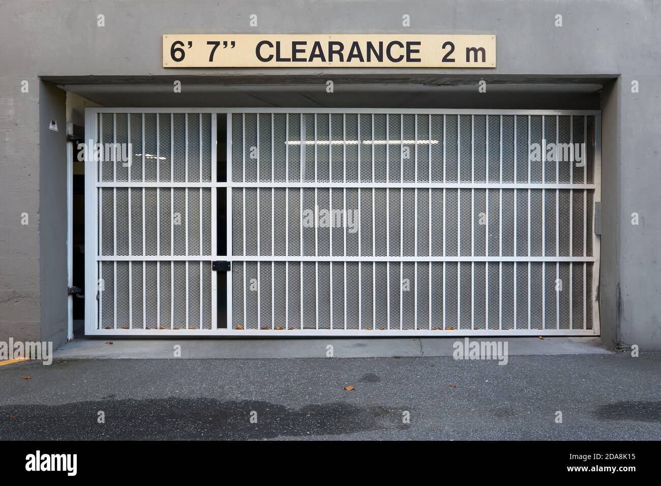 Metal car garage door with clearance height sign in both metric and imperial units, Vancouver, BC, Canada Stock Photo